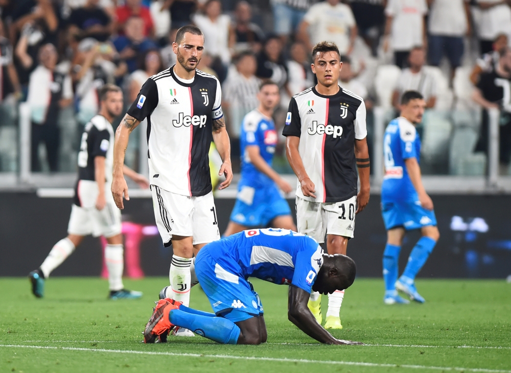 Napoli's Kalidou Koulibaly looks dejected after scoring an own goal and Juventus' fourth as Juventus' Leonardo Bonucci and Paulo Dybala walk towards him REUTERS/Massimo Pinca 