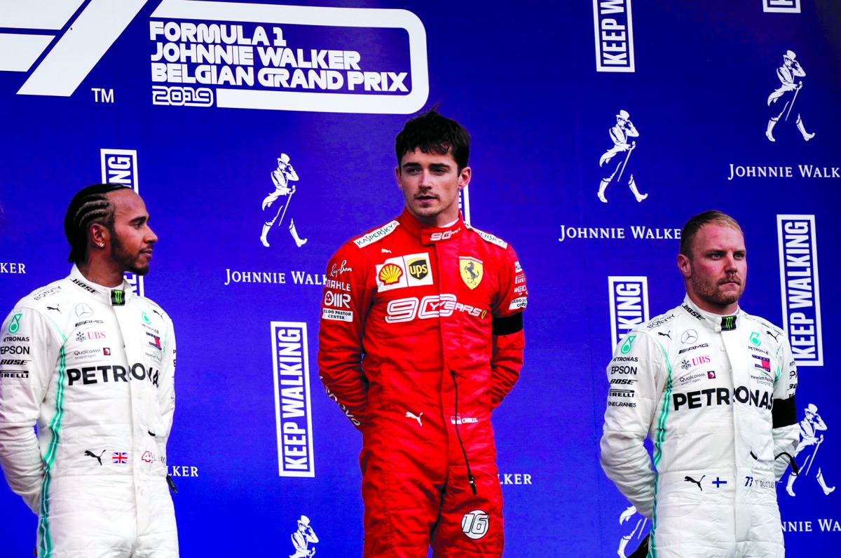 Winner Ferrari's Monegasque driver Charles Leclerc (C), second placed Mercedes' British driver Lewis Hamilton (L) and third placed Mercedes' Finnish driver Valtteri Bottas (R) celebrate on the podium after the Belgian Formula One Grand Prix at the Spa-Fra