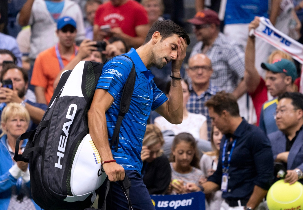 Novak Djokovic of Serbia leaves the court as he concedes the match to Stan Wawrinka of Switzerland during their Round Four Men's Singles match at the 2019 US Open at the USTA Billie Jean King National Tennis Center in New York on September 1, 2019. AFP / 