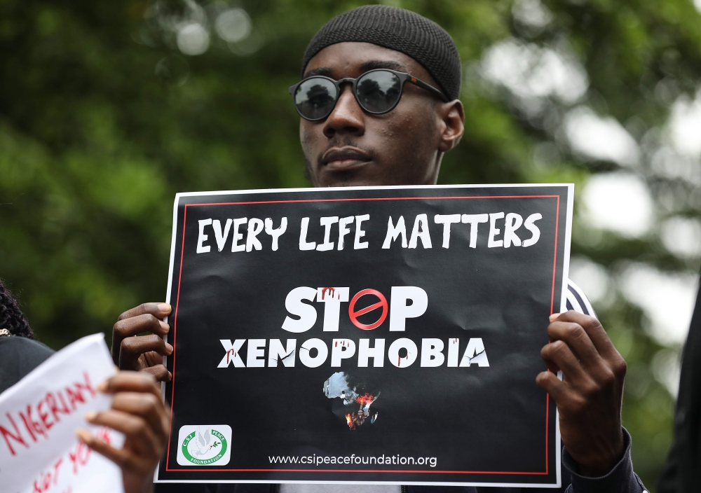 A demonstrator holds a sign during a protest against xenophobia outside of the main gate of the South African High Commission which was shut down to avert reprisal attacks in Abuja, on September 5, 2019.  AFP / Kola Sulaimon
 