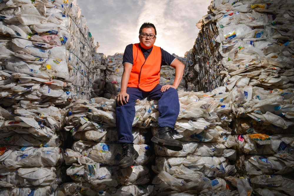 Northern Adelaide Waste Management Authority supervisor Thao Nguyen posing amongst recycled plastic bottles at the recycling site in Edinburgh near Adelaide on April 17. 2019. AFP / Brenton Edwards