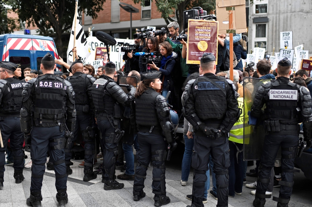 Journalists take photographs and videos above policemen as ecology activists demonstrate in front of Paris' courthouse in support of eight of them and one video journalist charged with 