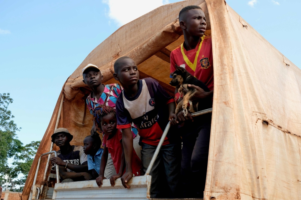 Central African refugees coming back after years in Congo-Brazzaville stand at the rear of a truck in Mongoumba, at the Congo-Brazzaville border, about 100 km south of Bangui on September 2, 2019. AFP / Camille Laffont 