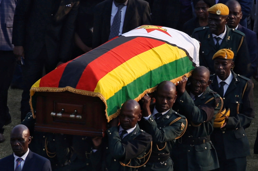 A casket carrying the remains of former Zimbabwean president Robert Mugabe is carried to the military chopper after his body lied in state at the Rufaro stadium, in Mbare, Harare, Zimbabwe, September 13, 2019. Reuters/Siphiwe Sibeko