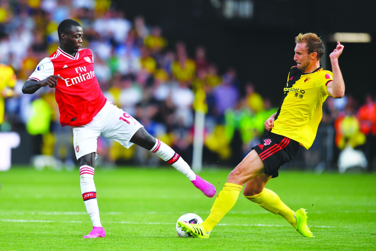 Arsenal's French-born Ivorian midfielder Nicolas Pepe (L) vies with Watford's English defender Craig Dawson during the English Premier League football match between Watford and Arsenal at Vicarage Road Stadium in Watford, north of London on September 15, 