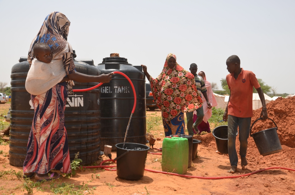 Displaced residents of Niamey collect water at tanks on September 11, 2019 in the makeshift camp of Saguia near the capital after the Niger river floods forced inhabitants out of the area. AFP / Boureima Hama  