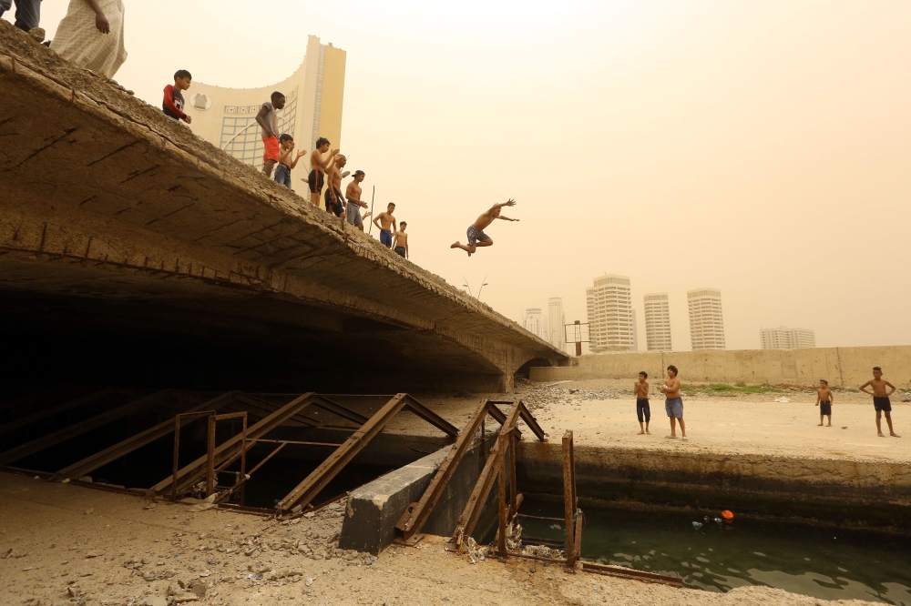 Libyan children play near the port of Tripoli on April 22, 2019. AFP/Mahmud Turkia
