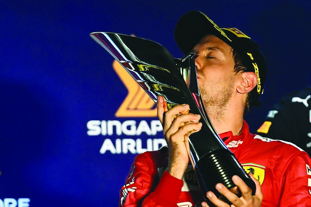 Sebastian Vettel kisses the trophy on the podium after winning the Formula One Singapore Grand Prix night race at the Marina Bay Street Circuit in Singapore on September 22, 2019.  AFP / Mohd Rasfan

