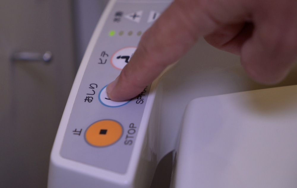 A person presses a button on the control panel of a Japanese toilet, in Tokyo, Japan September 24, 2019. REUTERS/Lucien Libert 