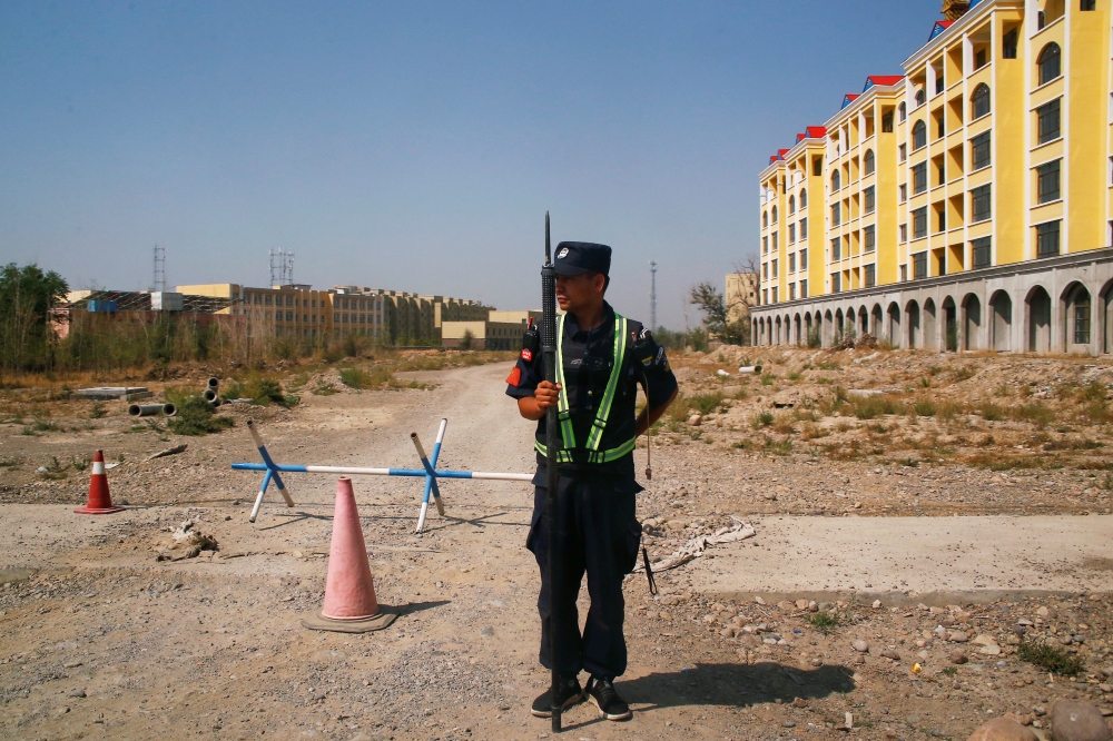A Chinese police officer takes his position by the road near a vocational education centre in Yining in Xinjiang Uighur Autonomous Region, China, September 4, 2018. Reuters / Thomas Peter