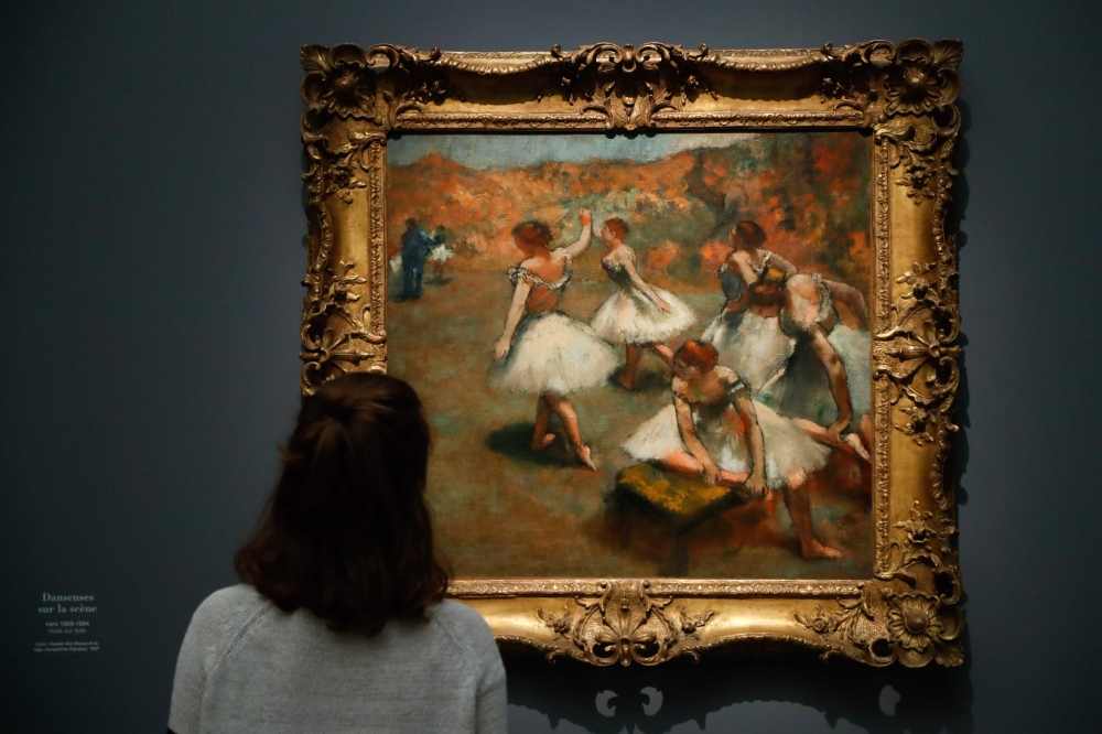 A person looks at the painting entitled 