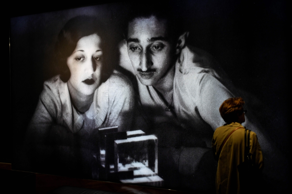 A woman walks past an image of Indian Prince, Yeshwant Rao Holkar II and his wife Sanyogita Devi of Indore, as she visits the opening of 