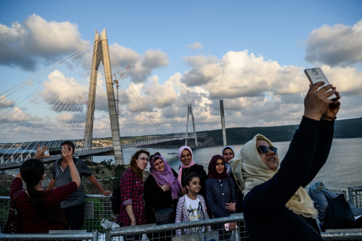 People take selfies as they pose next to the Yavuz Sultan Selim bridge on August 26, 2016, in Istanbul during the inauguration of the bridge. AFP