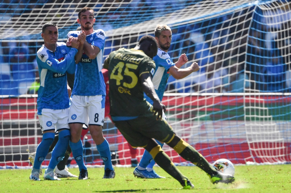 Brescia's Italian forward Mario Balotelli (Front) shoots a free kick as (FromL) Napoli's Spanish forward Jose Callejon, Napoli's Spanish defender Fabian Ruiz and Napoli's Belgian forward Dries Mertens jump to defend during the Italian Serie A football mat