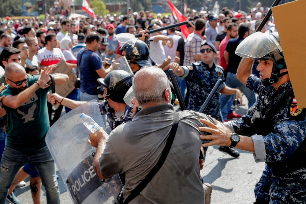 Lebanese protesters clash with riot policemen as they try to break through security barriers in front of the cabinet office during a demonstration in central Beirut's Martyr Square on September 29, 2019. AFP / ANWAR AMRO