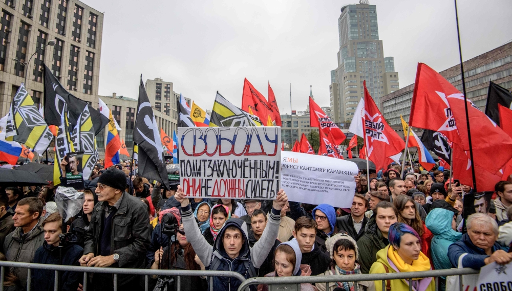 Russian opposition supporters wave flags and hold banners as they attend a demonstration in Moscow on September 29, 2019. AFP / Yuri Kadobnov 
