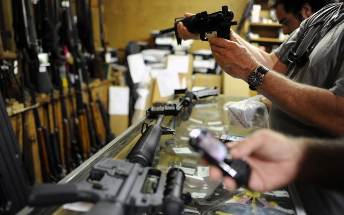 File photo Customers looking over the last two AR-15 style rifles for sale inside the Bullet Hole gun shop in Sarasota, Florida. (Reuters) 