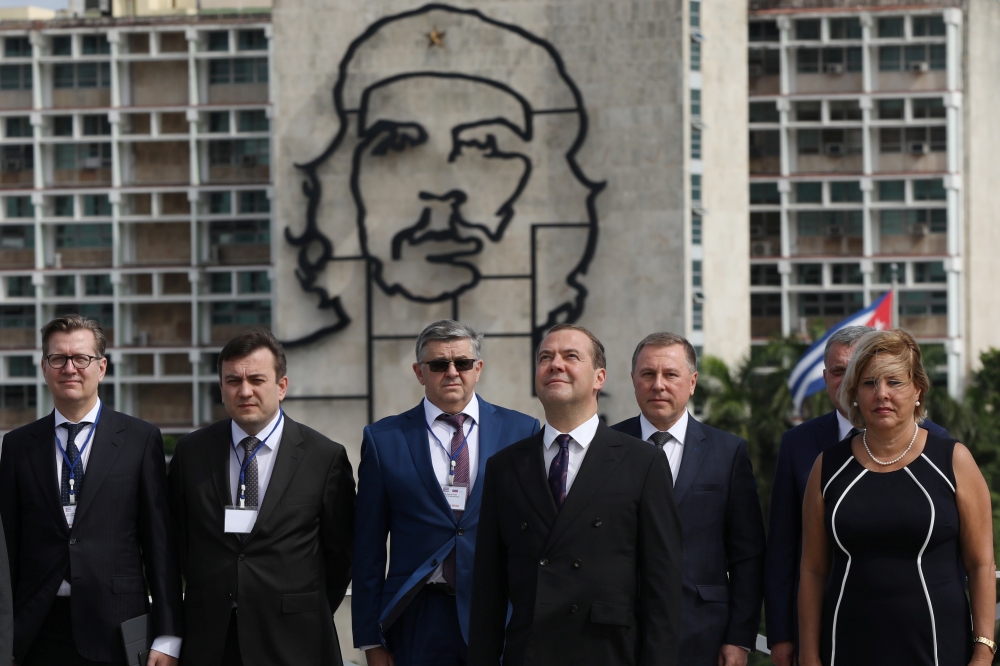 Russia's Prime Minister Dmitry Medvedev stands near an image of late revolutionary hero Ernesto 