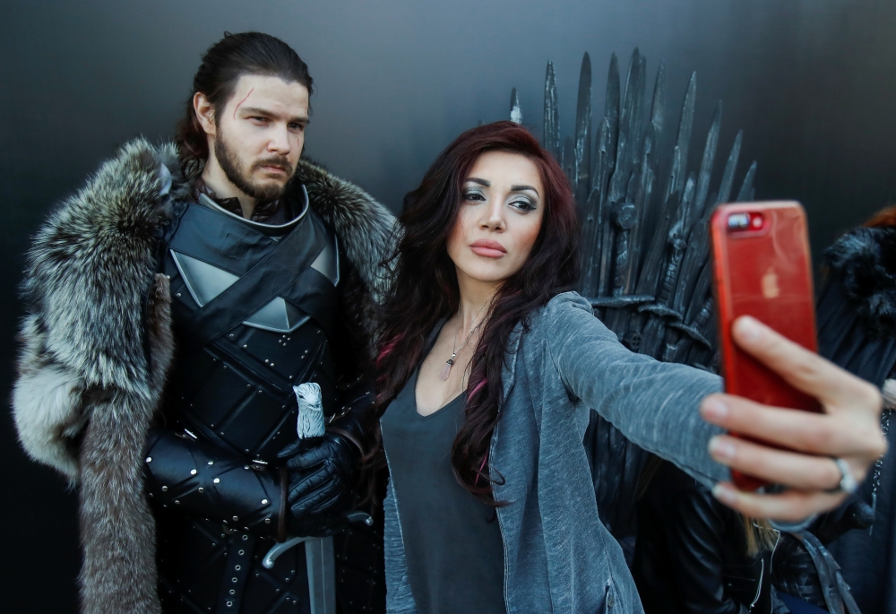 A woman shoots a selfie with an actor dressed like Jon Snow before the screening of final episode of Game of Thrones on 20-meter-high screen at RZD Arena in Moscow, May 20, 2019. Reuters / Maxim Shemetov