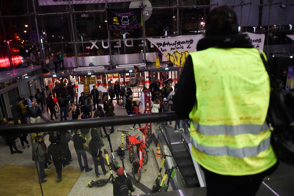 A yellow vest stands as protestors stay inside the Italie Deux shopping mall in Paris during a demonstration called by the Extinction Rebellion environmental activist movement, on October 5, 2019. AFP / Lucas Barioulet 