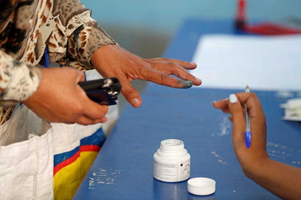 A woman has her finger stained with ink at a polling station during parliamentary elections, in Tunis, Tunisia October 6, 2019. REUTERS/Zoubeir Souissi
 