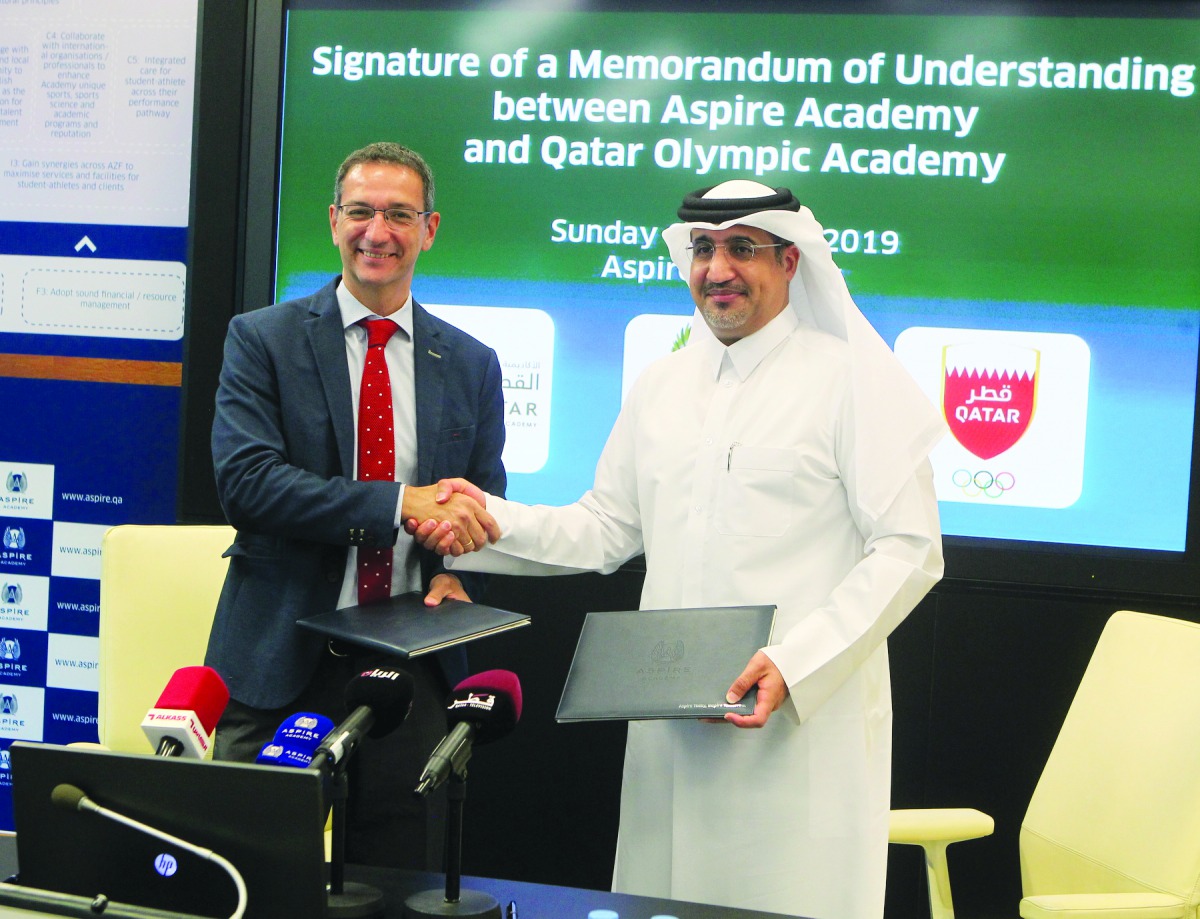 Aspire Academy Director General Ivan Bravo and Executive Director of Qatar Olympic Academy, Saif Mohammed Al Nuaimi exchanging documents during the MoU signing ceremony.
