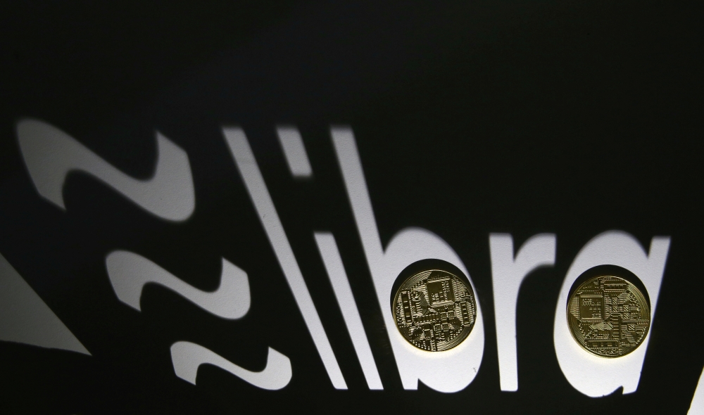 Shadow of a 3D-printed Facebook Libra cryptocurrency logo is seen near cryptocurrency representation in this illustration taken, September 13, 2019. REUTERS/Dado Ruvic/File Photo
