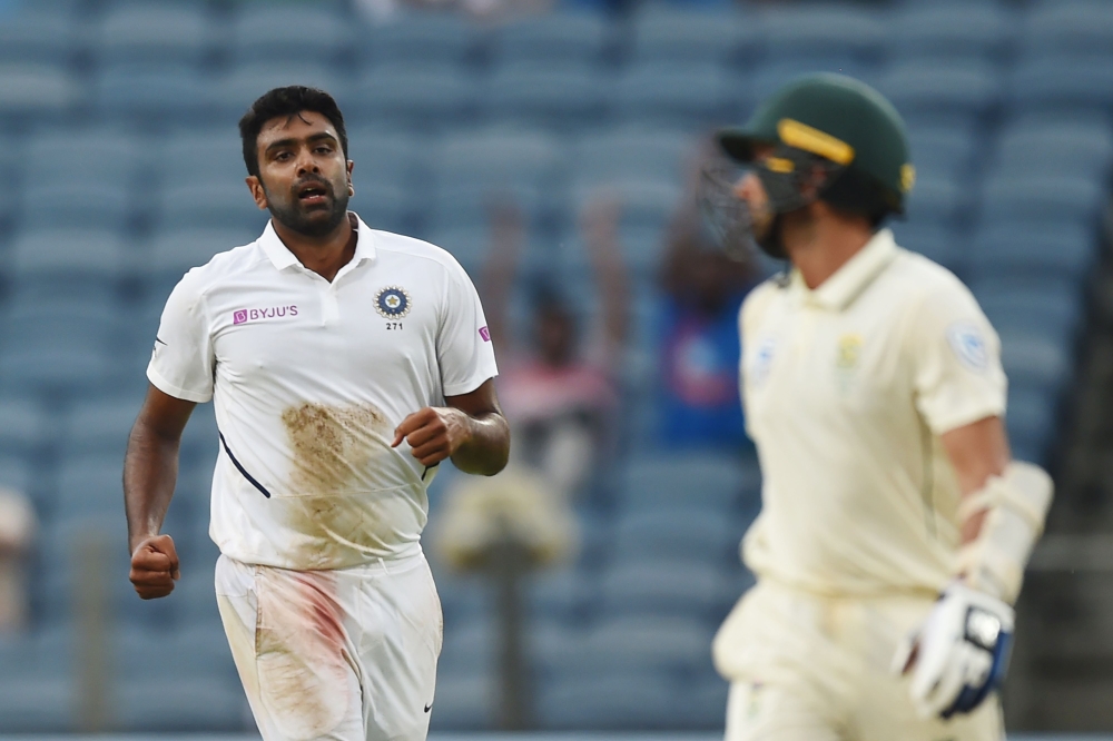 India's bowler Ravichandran Ashwin (L) celebrates after taking the wicket of South Africa's batsman Keshav Maharaj (R) during the third day play of second test cricket match between India and South Africa, at the Maharashtra Cricket Association Stadium in