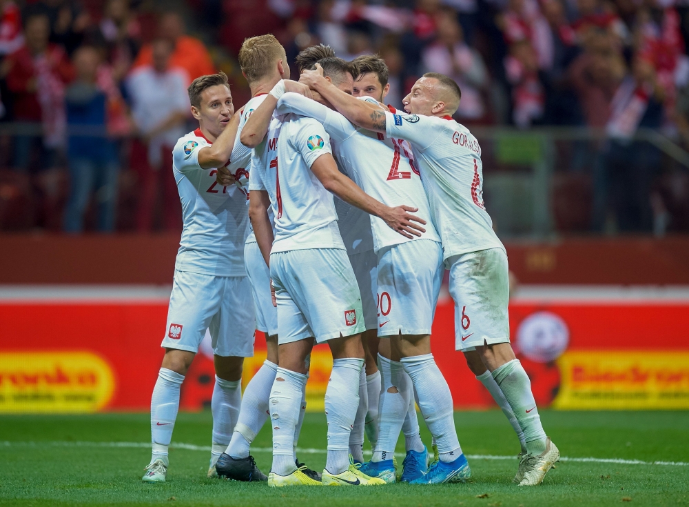 Poland's forward Arkadiusz Milik (2ndL) celebrates scoring the 2-0 with his team-mates during the Euro 2020 qualifier Group G football match Poland v Macedonia in Warsaw, Poland, on October 13, 2019. / AFP / Lukasz Szelag