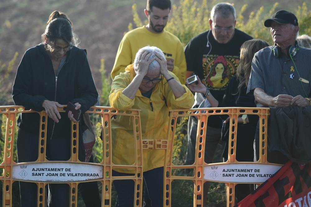 People react on October 14, 2019, outside Lledoners jail in Sant Joan de Vilatorrada, where Catalan leader Oriol Junqueras in jailed, after Spain's Supreme Court sentenced nine Catalan leaders to prison terms ranging from nine to 13 years for sedition and