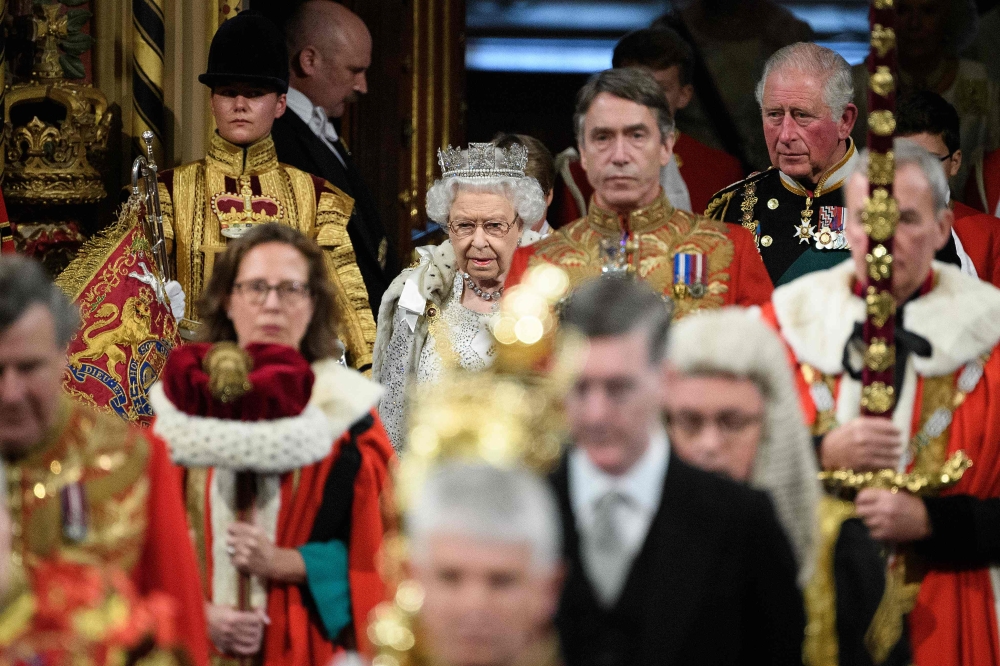 Britain's Queen Elizabeth II (C) and Britain's Prince Charles, Prince of Wales (top right) proceed through the Royal Gallery to deliver the Queen's speech at the State Opening of Parliament in the Houses of Parliament in London on October 14, 2019.   AFP 