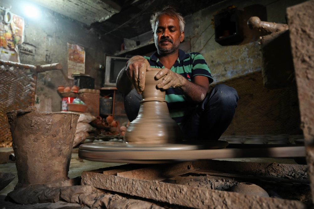 In this photograph taken on October 4, 2019, a potter makes a clay pot in his residence at Kumhar Gram (Potter's Village) in New Delhi. AFP / Money SHARMA