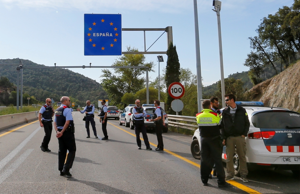 Spanish police officers and drivers stand on the motorway in Le Perthus near the Franco-Spanish border as Catalan demonstrators block the Spanish motorway during Catalonia's general strike, France, October 19, 2019, 2019. REUTERS/Regis Duvignau
