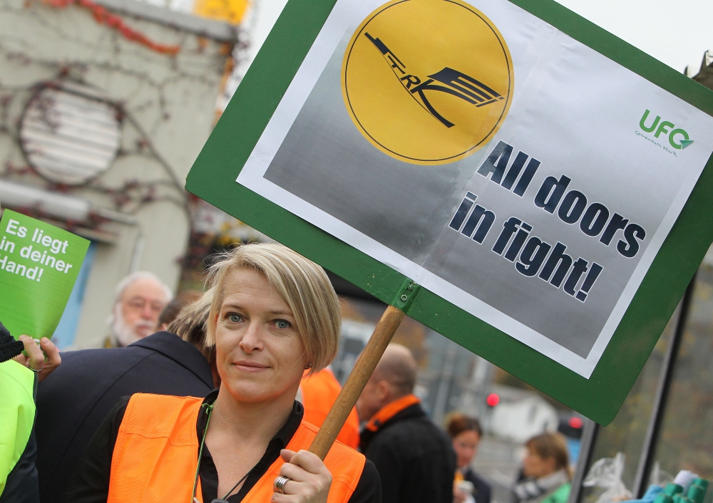 (FILES) This file photo taken on November 6, 2015 shows a cabin staff of German airline Lufthansa holding a placard during a demonstration outside the airport in Frankfurt am Main, western Germany. AFP / DANIEL ROLAND