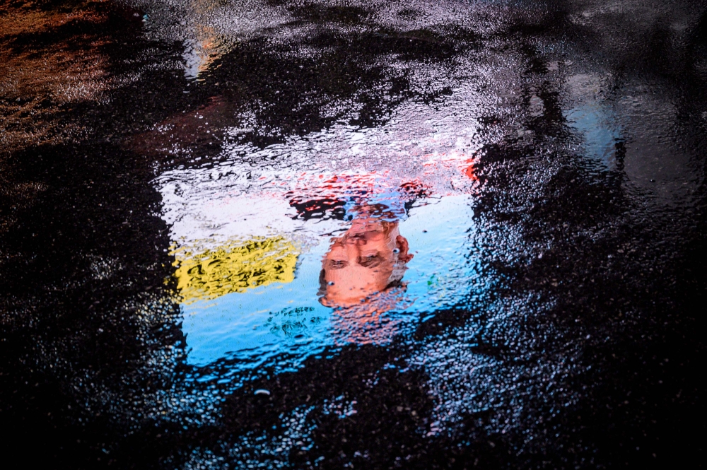 This picture shows an electoral poster of the candidate of the anti-immigrant right-wing Swiss People's Party (SVP) Jean-François Thuillard reflected in a puddle on October 18, 2019 in Chavannes de Bogis, Western Switzerland. AFP / Fabrice COFFRINI