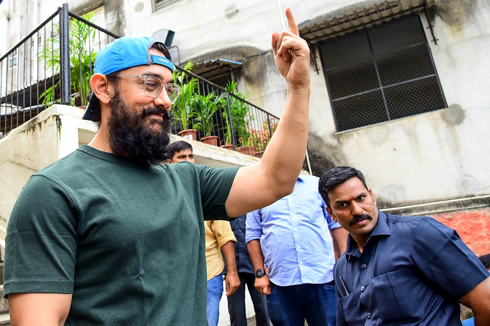 Bollywood actor Aamir Khan shows his inked finger after casting his vote at a polling station during the state assembly election in Mumbai on October 21, 2019. / AFP / Sujit Jaiswal