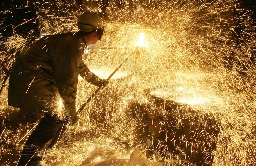 In this file photo taken on April 12 2006 an iron and steel worker makes a test on a casting. AFP / Boris Horvat