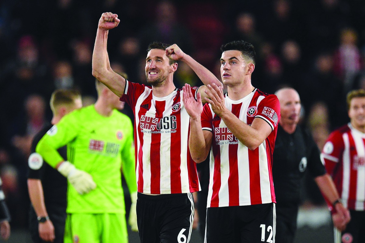 Sheffield United's English defender Chris Basham (L) and Sheffield United's Irish defender John Egan (R) celebrate on the pitch after the English Premier League football match between Sheffield United and Arsenal at Bramall Lane in Sheffield, northern Eng