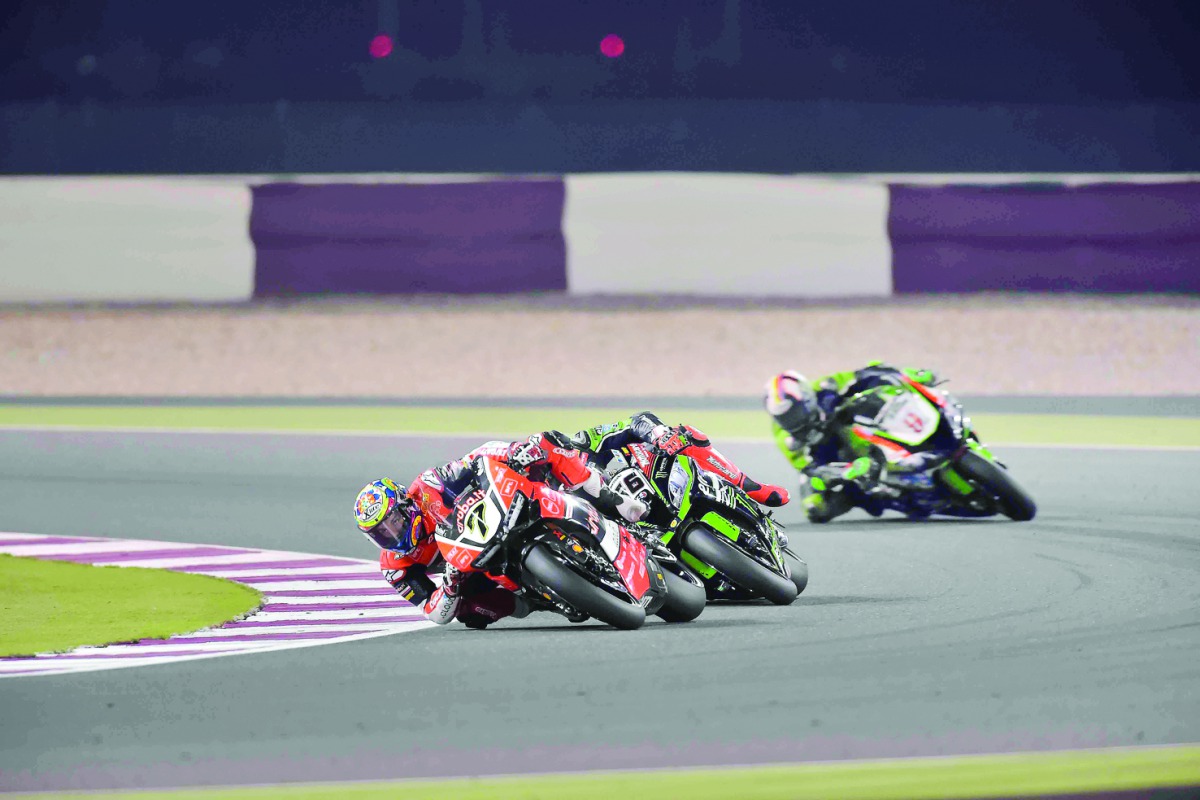 Chaz Davies of Aruba.it Racing-Ducati (front) takes a turn ahead of Jonathan Rea (centre) of Kawasaki Racing FIM WorldSBK Race 2 at the Losail International Circuit in this file picture.