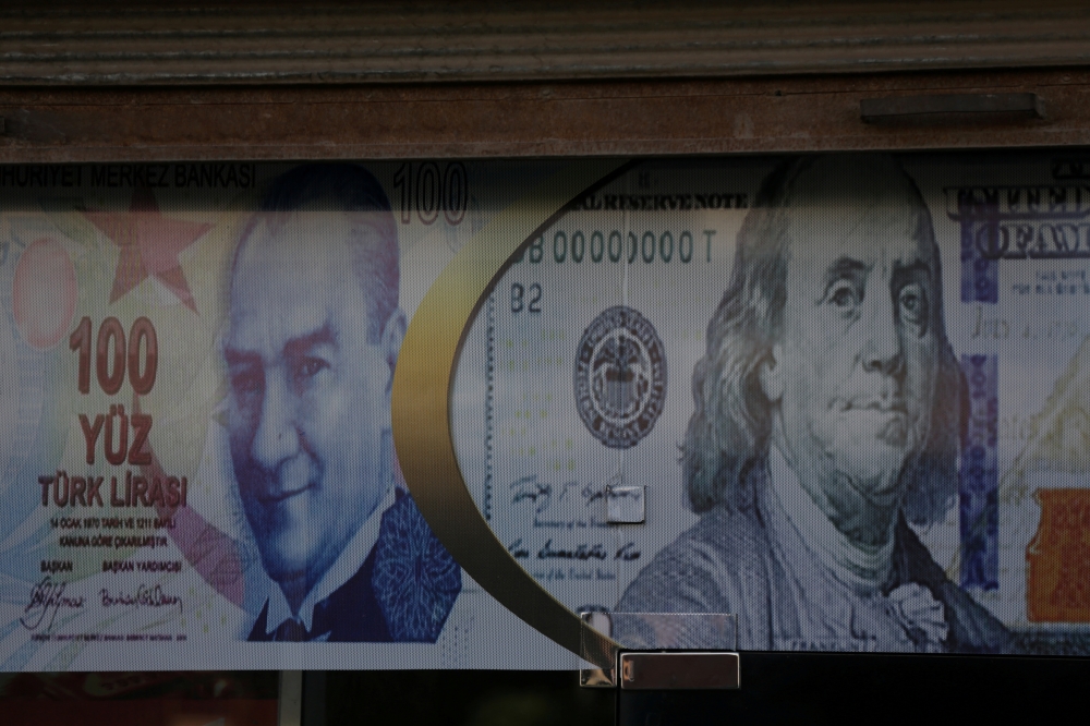 FILE PHOTO: Posters of U.S. dollar and Turkish lira are seen on a currency exchange shop in the city of Azaz, Syria August 18, 2018. Picture taken August 18, 2018. REUTERS/ Khalil Ashawi