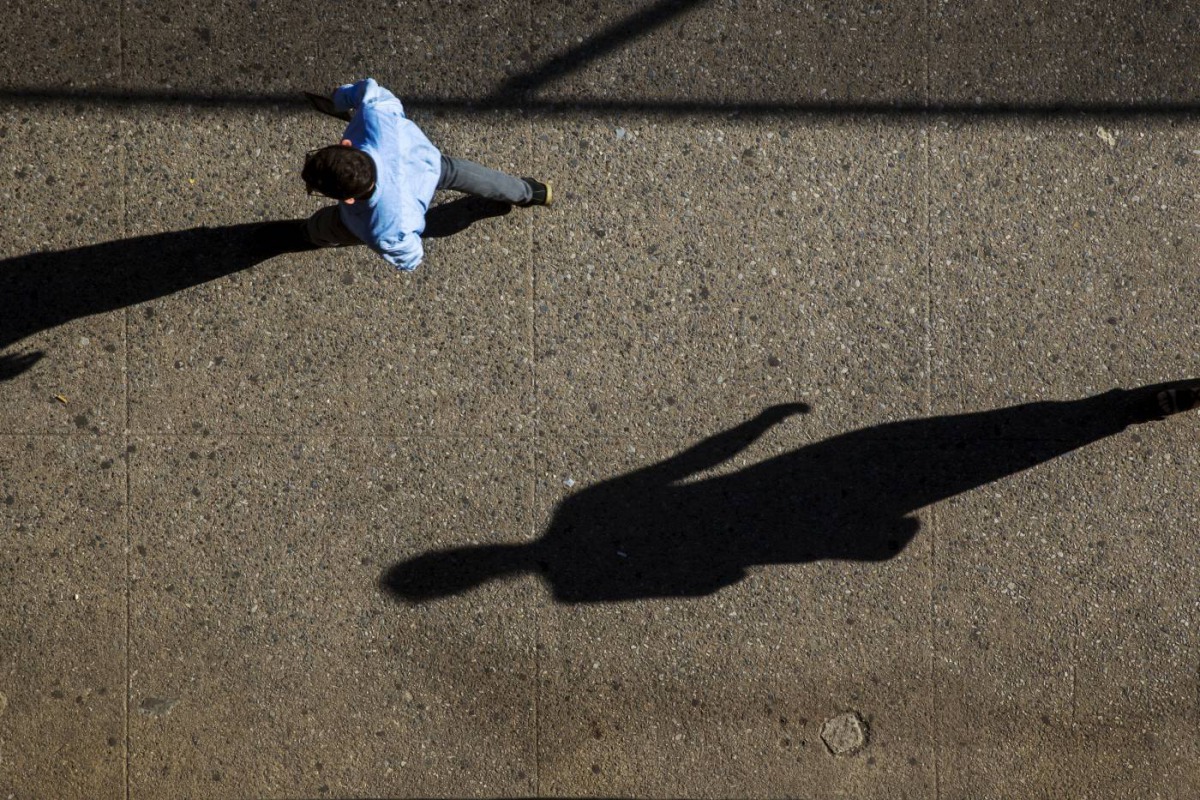 The morning sun casts long shadows as commuters walk along a sidewalk in New York August 28, 2015. Reuters/Lucas Jackson