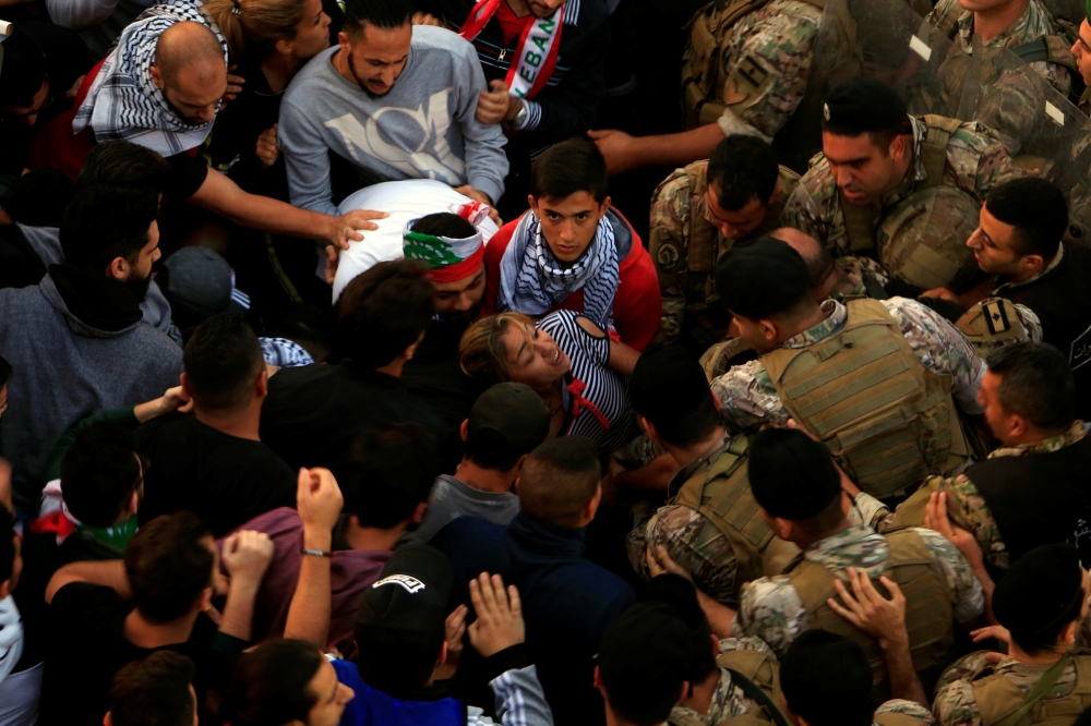 Lebanese army soldiers confront demonstrators in an attempt to open a road blocked by them during ongoing anti-government protests in the port city of Sidon, Lebanon October 28, 2019. REUTERS/Ali Hashisho