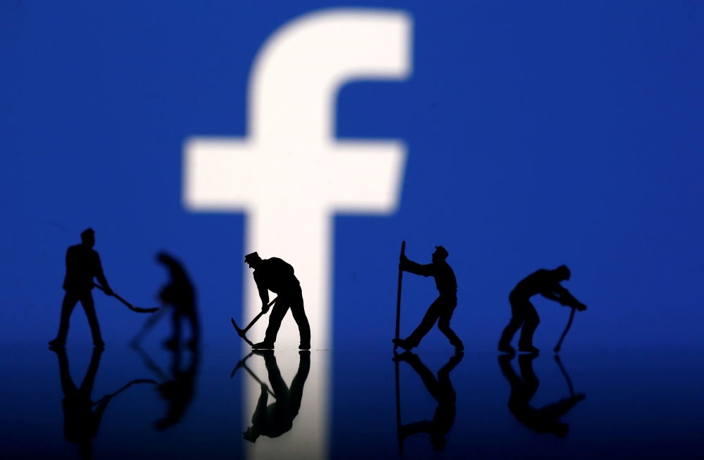 FILE PHOTO: Figurines are seen in front of the Facebook logo in this illustration taken March 20, 2018. REUTERS
