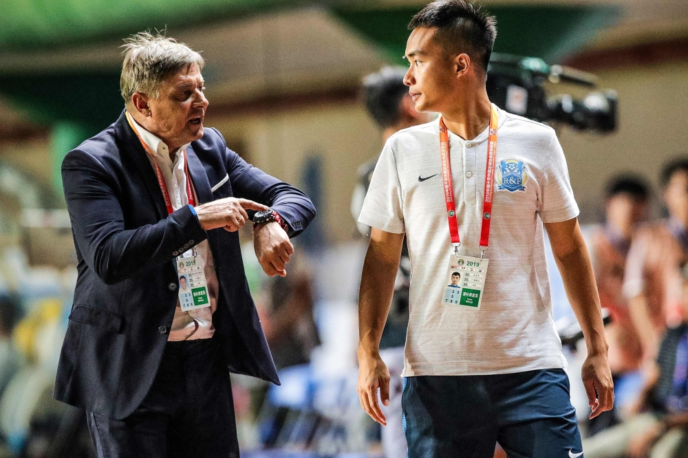 Guangzhou R&F head coach Dragan Stojkovic (L) speaking with translator Hong Wenjie during their Chinese Super League football match with Shandong Luneng in Guangzhou in China's southern Guangdong province on October 19, 2019. AFP