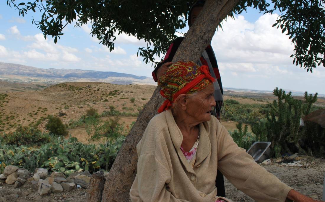 Grandmother Massouda Barhoumi sits under a tree on her family's land, which is a 4km walk from the nearest source of water, in the central region of Kairouan, Tunisia on September 2, 2019. Thomson Reuters Foundation/Layli Foroudi