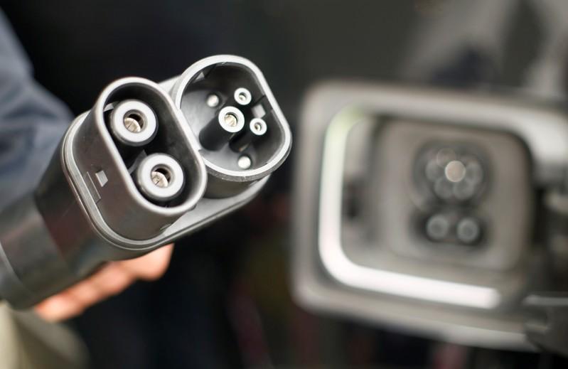 A man holds DC-power charging plug of his BMW i3 electric car during the presentation of a new super-fast multi-charging power column comfort charge belonging to Deutsche Telekom. Reuters / Wolfgang Rattay
