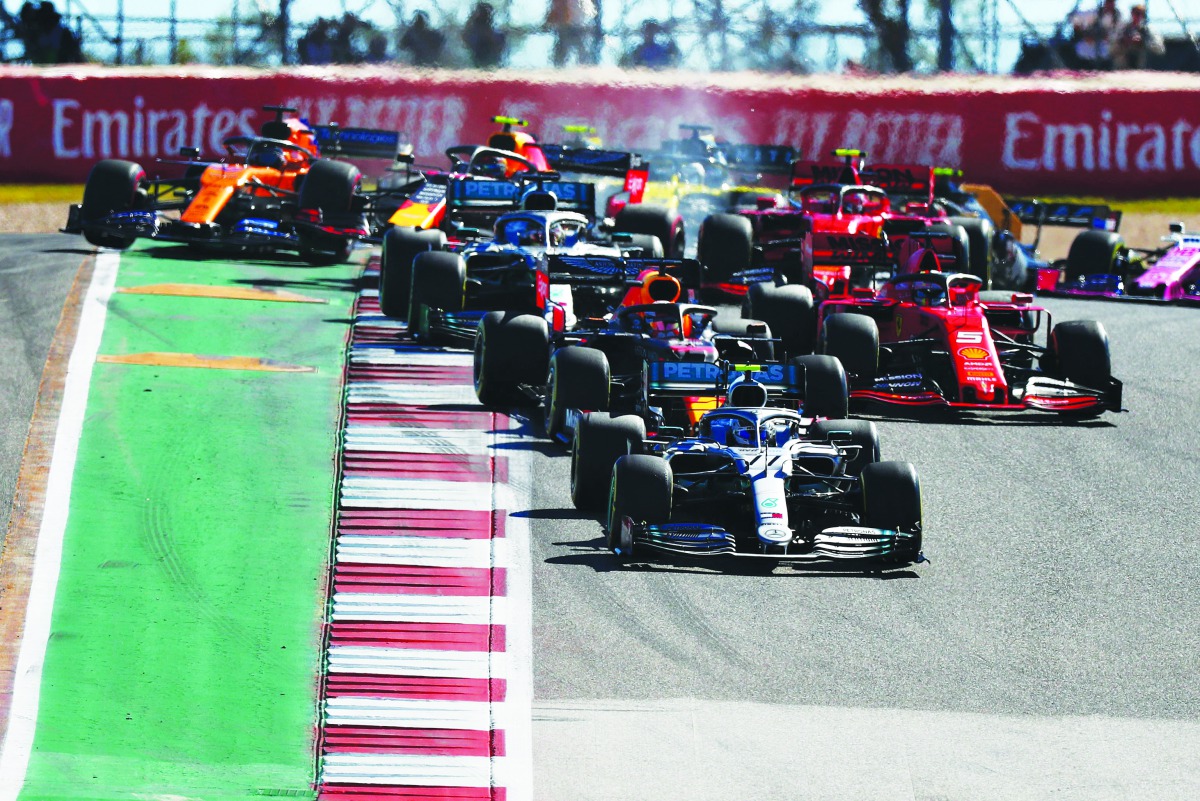 Valtteri Bottas driving the (77) Mercedes AMG Petronas F1 Team Mercedes W10 leads Max Verstappen of the Netherlands driving the (33) Aston Martin Red Bull Racing RB15 and the rest of the field into turn two at the start during the F1 Grand Prix of USA at 