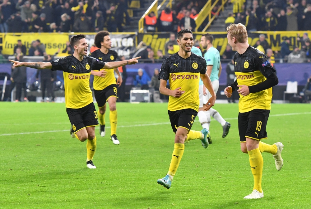 Dortmund's Moroccan defender Achraf Hakimi (C) celebrate scoring the 3-2 goal with his team-mates in the second half of the UEFA Champions League Group F football match BVB Borussia Dortmund v Inter Milan in Dortmund, western Germany, on November 5, 2019.