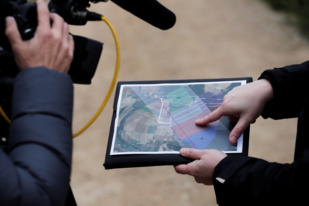 A member of the France's BEA aviation safety agency shows a map during a scour of an uninhabited wood to find pieces of the engine of a Swiss Air Lines Airbus A220 which fell from the aircraft mid-flight, in Perrigny-sur-Armancon, France, November 6, 2019