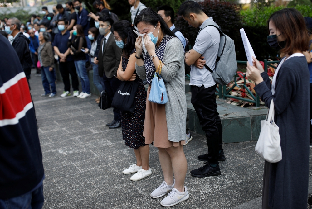 A woman weeps as she attends a gathering to pay tribute to Chow Tsz-lok, 22, a university student who fell during protests at the weekend and died early on Friday morning, in Hong Kong, China November 8, 2019. REUTERS/Ahmad Masood
 